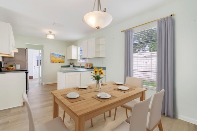 dining area featuring light hardwood / wood-style floors, a healthy amount of sunlight, and sink