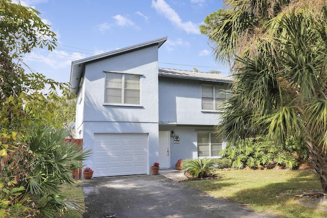 view of front of home with a front yard and a garage