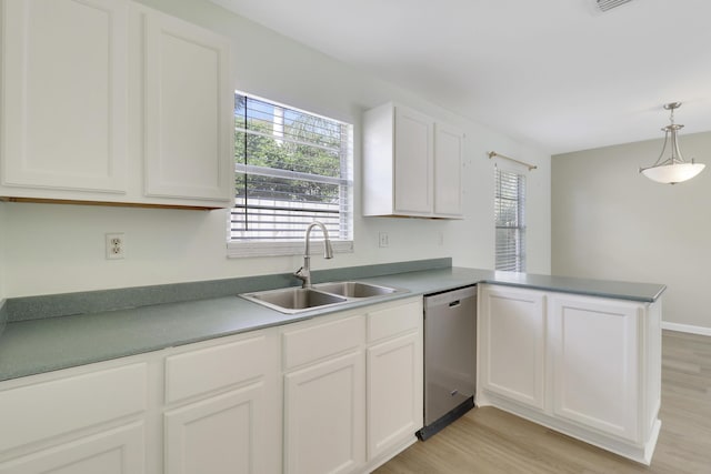 kitchen featuring kitchen peninsula, dishwasher, sink, and a healthy amount of sunlight