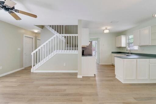 kitchen featuring light hardwood / wood-style floors, white cabinetry, ceiling fan, and sink