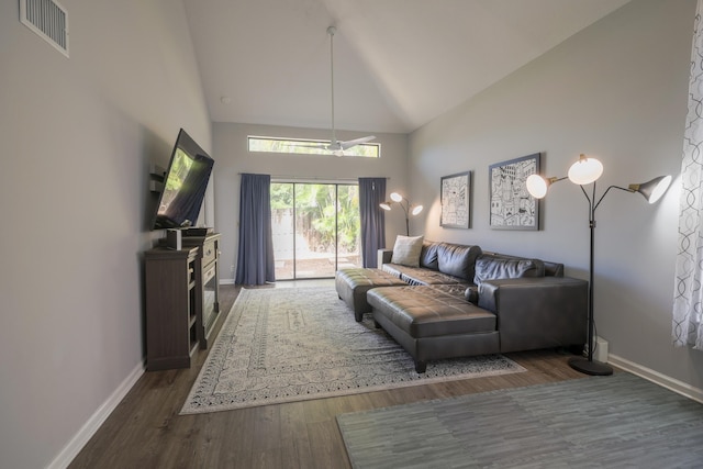 living room with dark hardwood / wood-style flooring and high vaulted ceiling