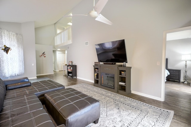 living room featuring ceiling fan, dark wood-type flooring, and high vaulted ceiling