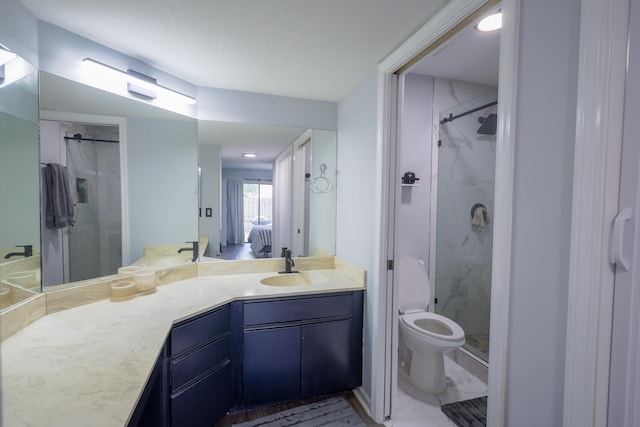 bathroom with vanity, toilet, a shower with shower door, and a textured ceiling