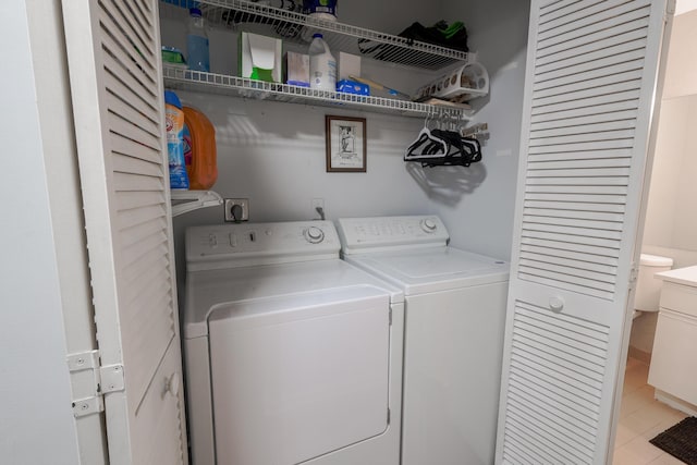 laundry room with light tile patterned floors and separate washer and dryer