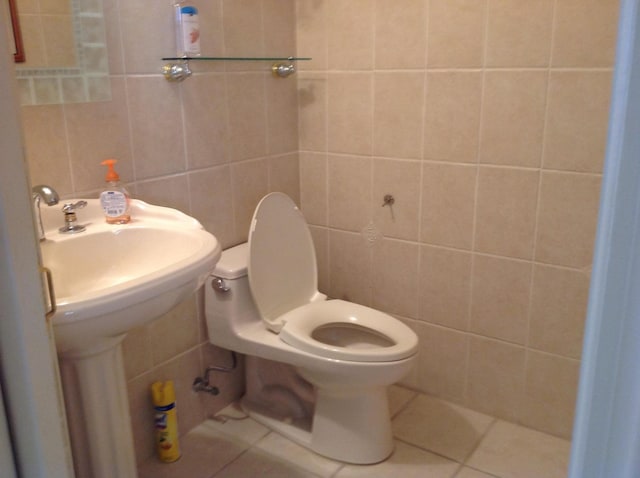 bathroom with tile patterned flooring, sink, tile walls, and toilet