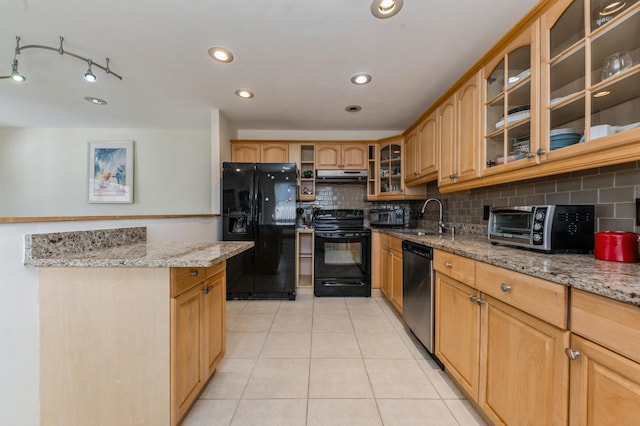 kitchen featuring light tile patterned floors, light stone countertops, sink, and black appliances