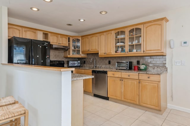 kitchen with dishwasher, black fridge, light tile patterned floors, and decorative backsplash