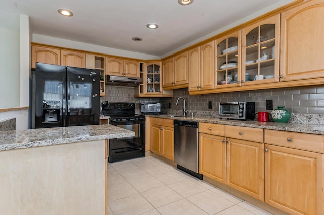 kitchen featuring sink, light tile patterned floors, light stone counters, tasteful backsplash, and black appliances