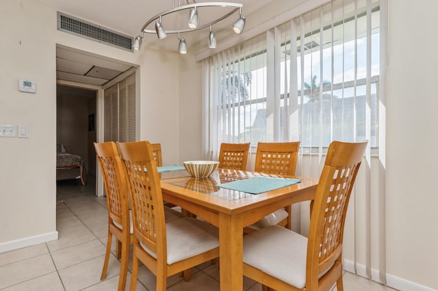 dining space featuring rail lighting and light tile patterned floors