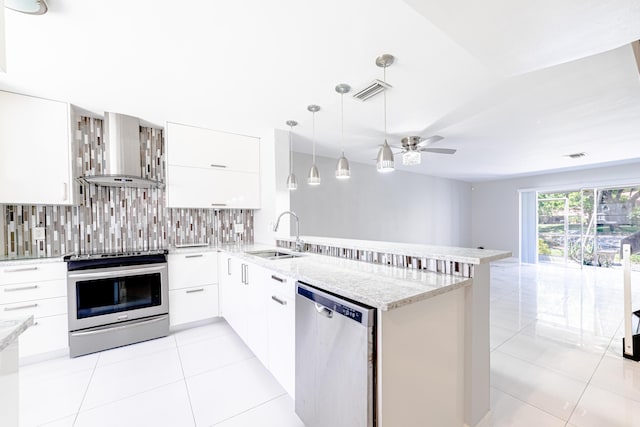 kitchen featuring white cabinets, kitchen peninsula, sink, and appliances with stainless steel finishes