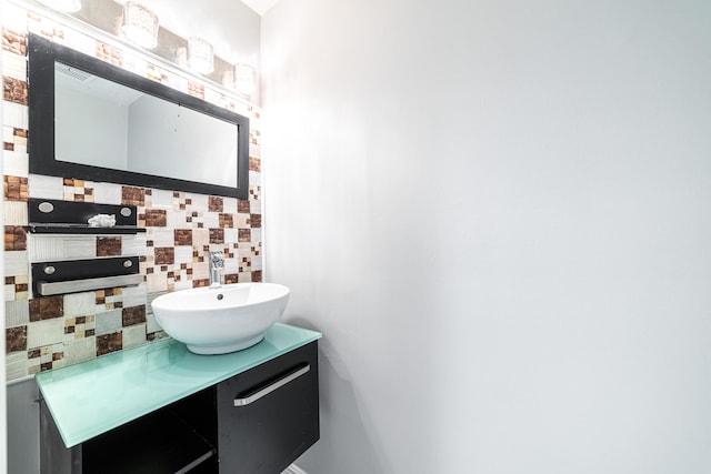 bathroom featuring vanity and backsplash