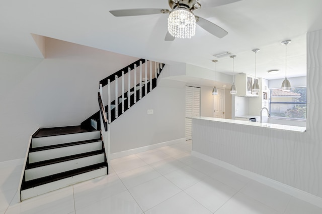 staircase with tile patterned flooring, ceiling fan, and sink