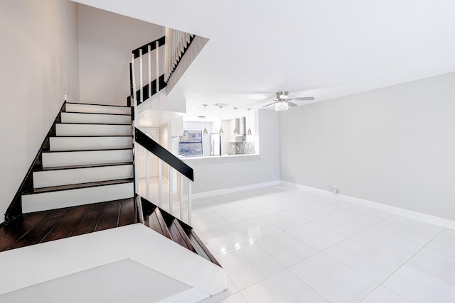 stairs featuring tile patterned flooring and ceiling fan