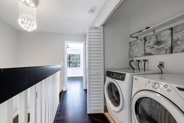 washroom with dark hardwood / wood-style flooring, washing machine and dryer, and a notable chandelier