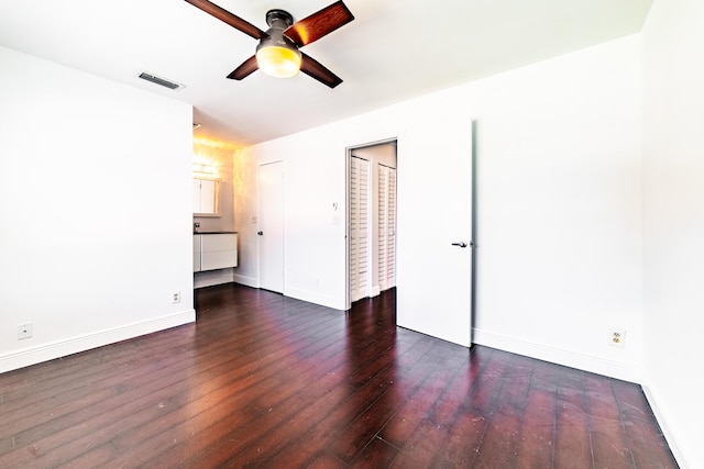 unfurnished room with ceiling fan and dark wood-type flooring