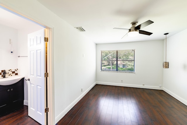 empty room with ceiling fan, dark hardwood / wood-style flooring, and sink