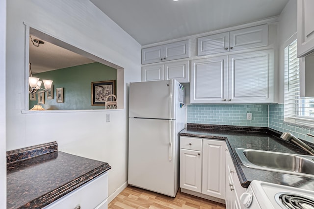 kitchen with white appliances, sink, light wood-type flooring, plenty of natural light, and white cabinetry