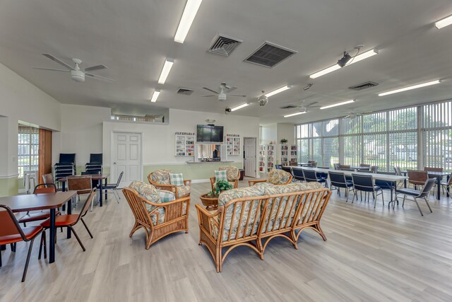 living room featuring a wealth of natural light, ceiling fan, and light wood-type flooring