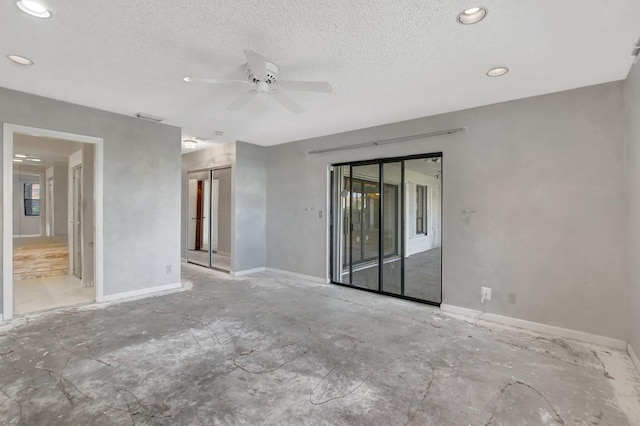 unfurnished room with ceiling fan and a textured ceiling