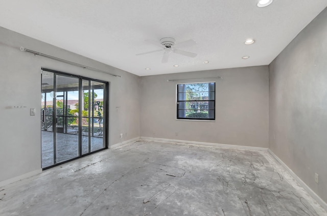 unfurnished room with ceiling fan and a textured ceiling