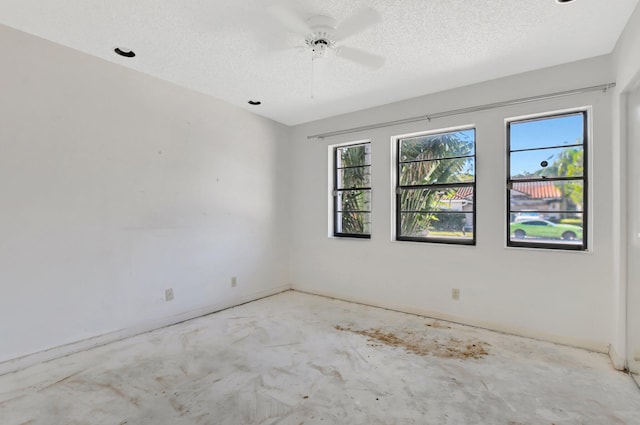 unfurnished room with ceiling fan and a textured ceiling