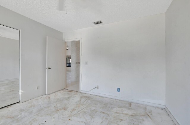 spare room featuring ceiling fan and a textured ceiling