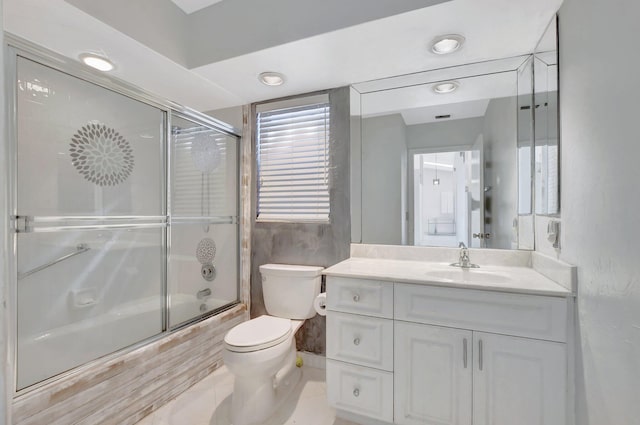 full bathroom featuring toilet, vanity, and bath / shower combo with glass door