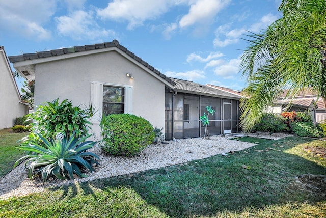 rear view of property with a yard and a sunroom