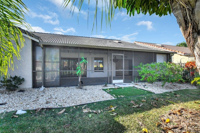 rear view of house with a sunroom and a yard