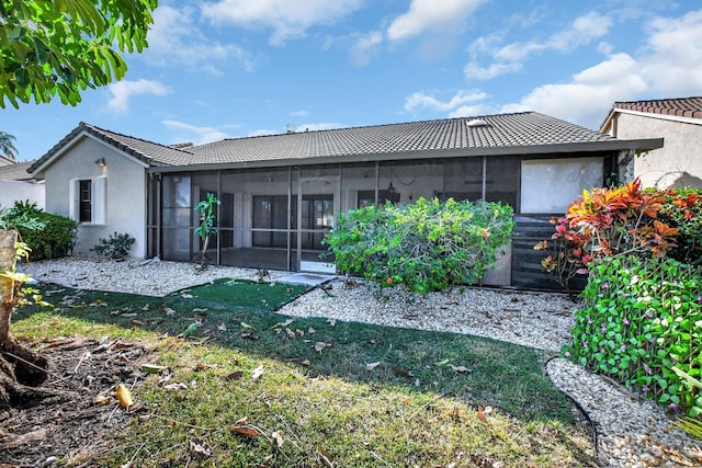 back of house featuring a sunroom and a lawn