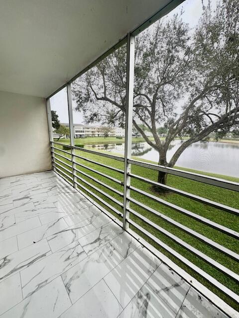 unfurnished sunroom featuring a water view