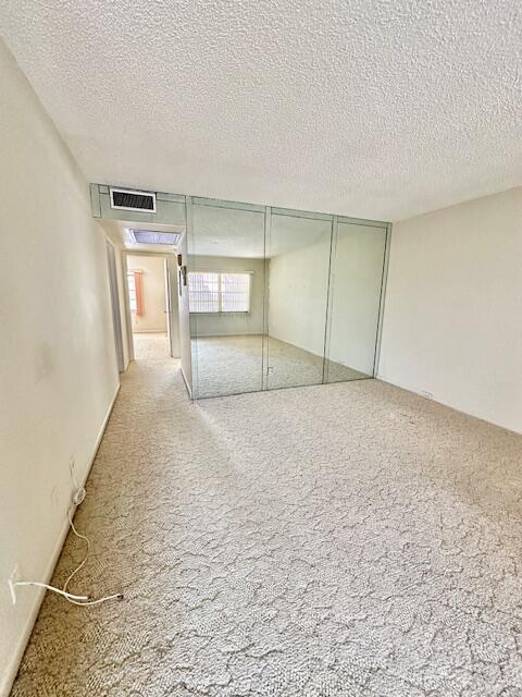 interior space with light carpet and a textured ceiling