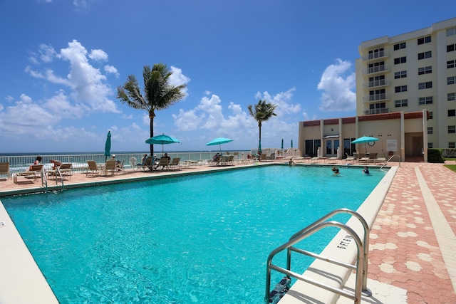 view of pool with a patio area and a water view