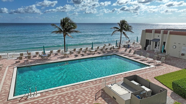 view of pool with a water view and a patio area