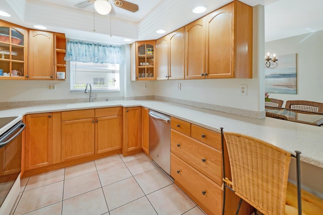 kitchen with sink, a tray ceiling, light tile patterned floors, ceiling fan with notable chandelier, and appliances with stainless steel finishes