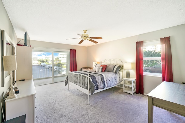 bedroom featuring access to exterior, light carpet, multiple windows, and ceiling fan