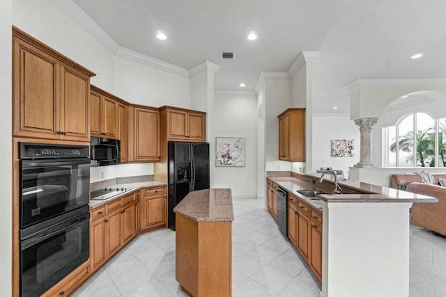 kitchen with black appliances, kitchen peninsula, crown molding, and decorative columns