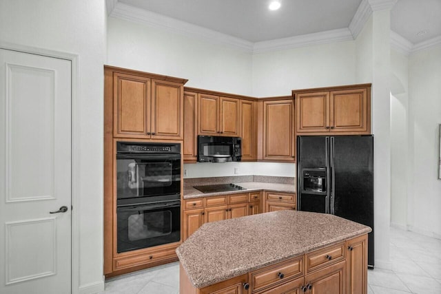 kitchen with black appliances, a kitchen island, ornamental molding, light tile patterned flooring, and light stone counters