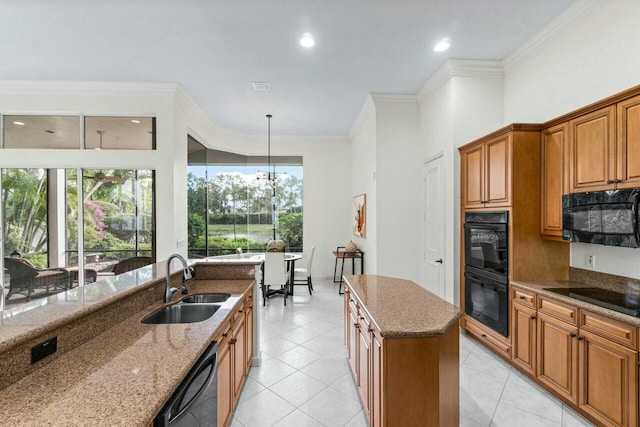 kitchen with sink, light stone counters, crown molding, a kitchen island, and black appliances