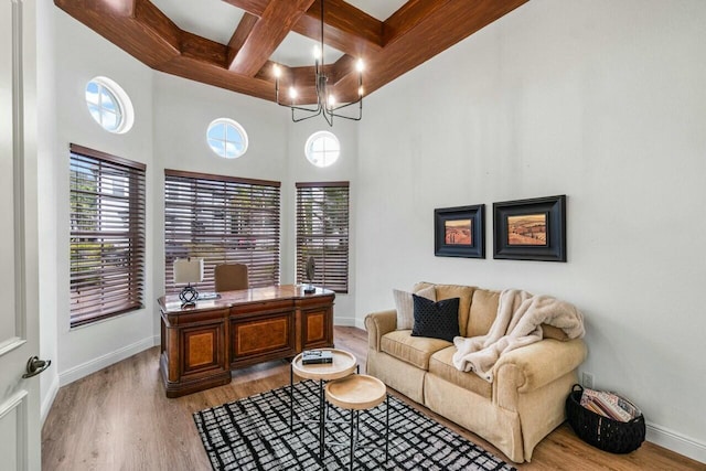 office space with beam ceiling, a towering ceiling, coffered ceiling, and hardwood / wood-style flooring