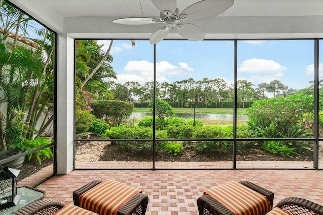 sunroom featuring a water view