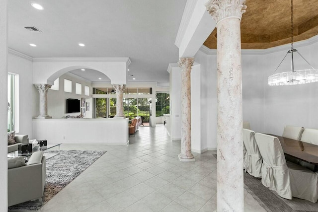 interior space with ornate columns, ornamental molding, and a chandelier