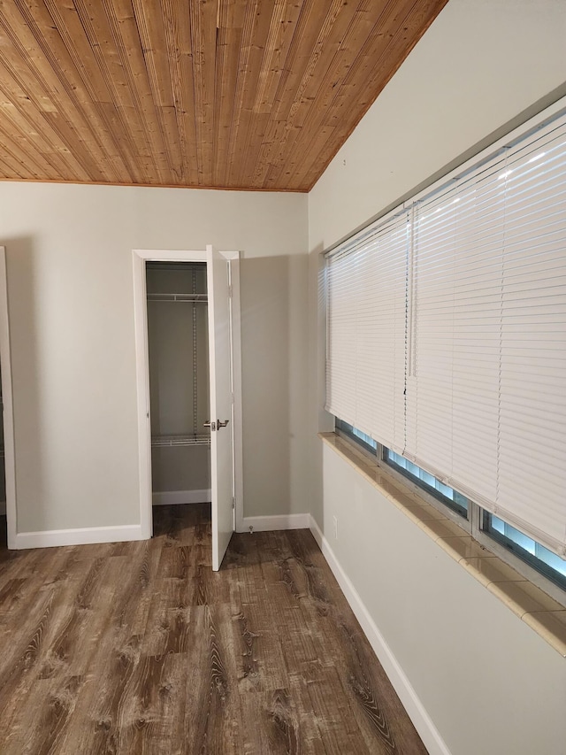 unfurnished bedroom with a closet, dark hardwood / wood-style flooring, and wood ceiling