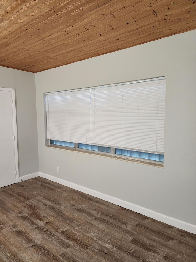 unfurnished room with dark wood-type flooring and wood ceiling