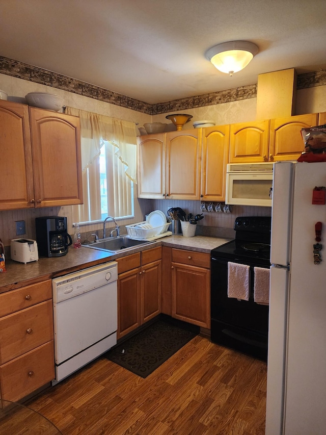 kitchen featuring white appliances, dark hardwood / wood-style floors, and sink