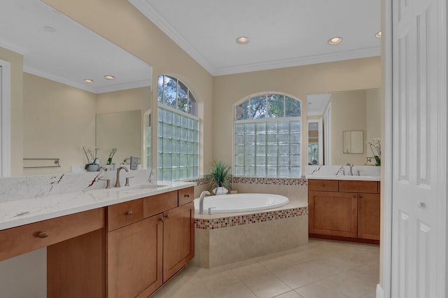 bathroom with tile patterned floors, vanity, crown molding, and tiled tub