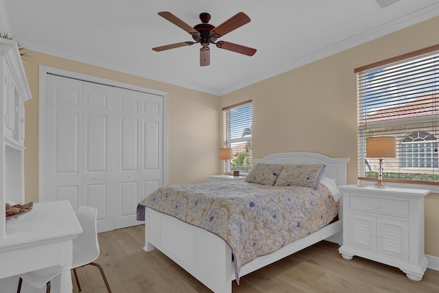 bedroom with ceiling fan, a closet, ornamental molding, and light wood-type flooring