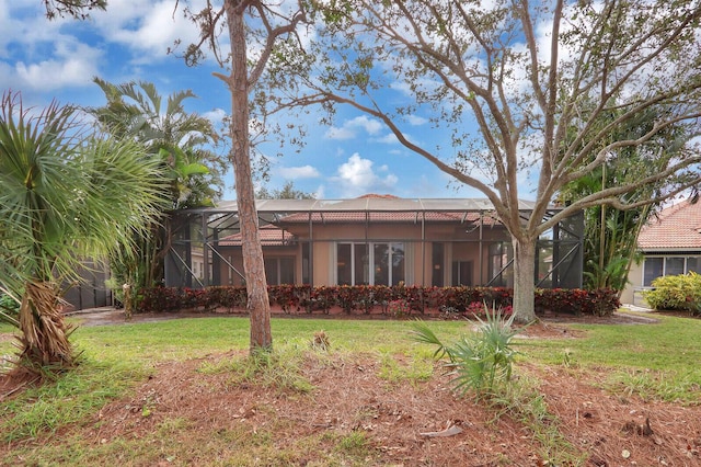 back of property with a lanai and a yard