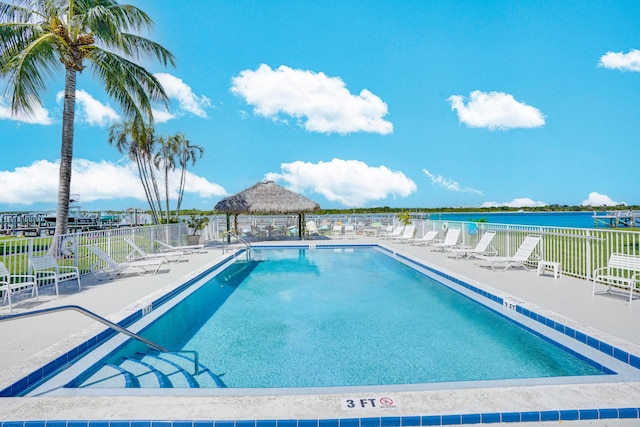 view of swimming pool with a water view and a patio area