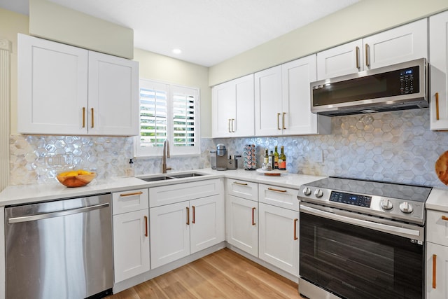 kitchen with backsplash, white cabinetry, sink, and appliances with stainless steel finishes